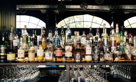 Bottles of whiskey sitting on a shelf.