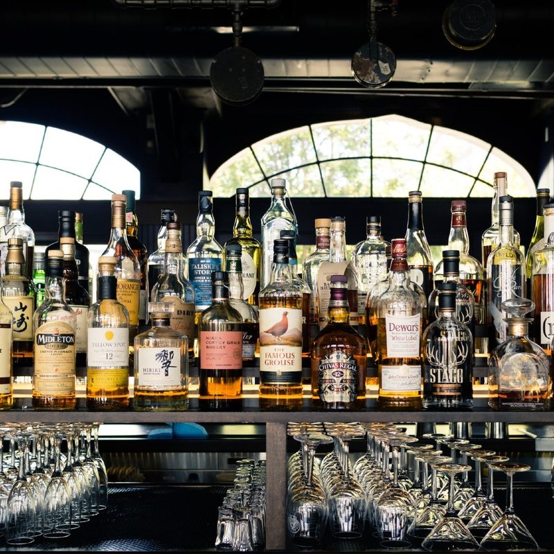 Bottles of whiskey sitting on a shelf.
