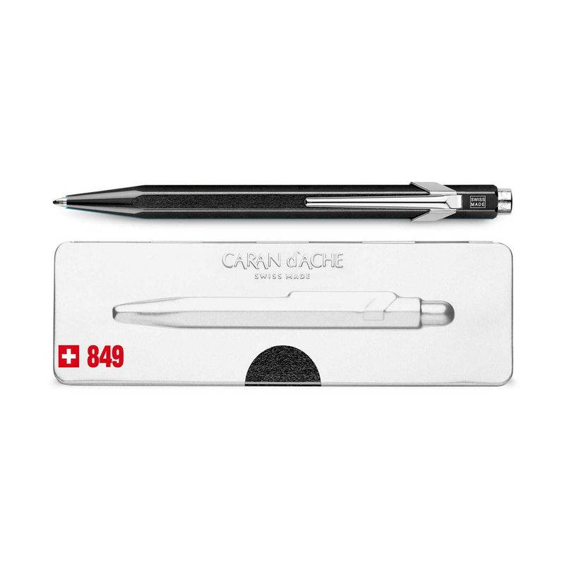 A black Caran d&rsquo;Ache 849 Ballpoint Pen and its pen holder.