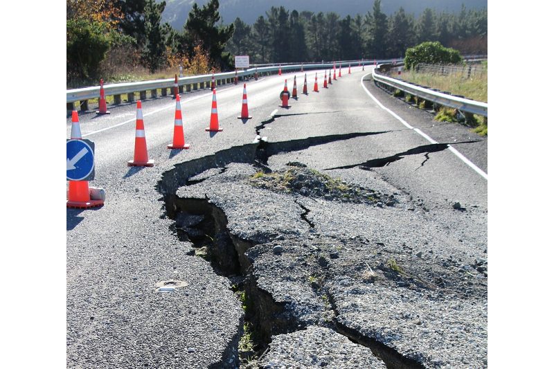 A blocked-off crumbling roadway.