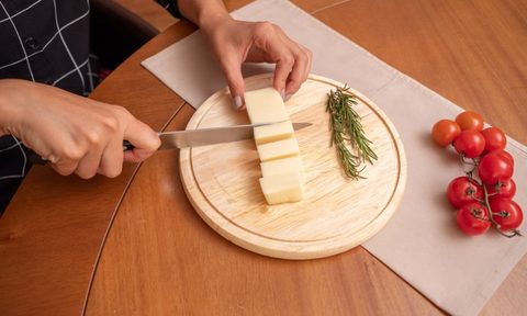 hands cutting butter on a cutting board.