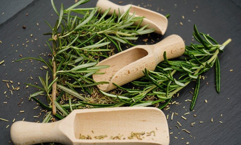 wooden spoons with fresh and dried herbs.