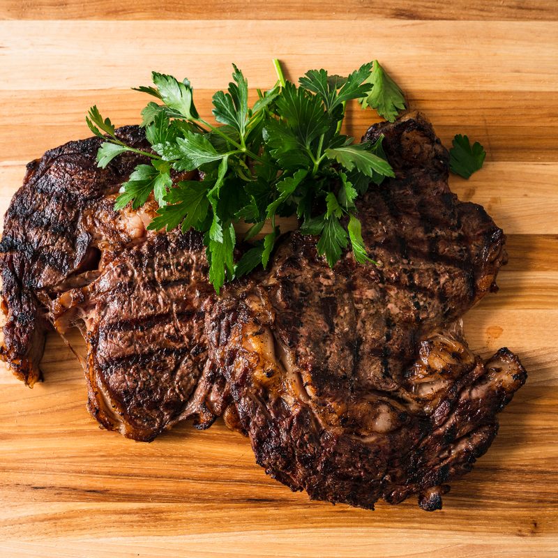 Grilled ribeyes steaks from E3 Ranch on cutting board.