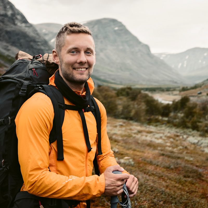 A smiling man carrying a backpack.