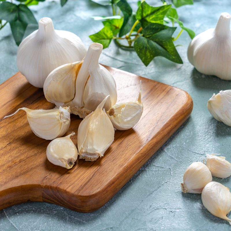 Garlic on wooden cutting board.