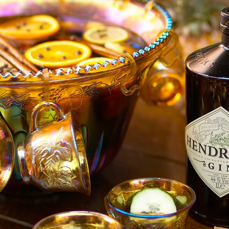 A bowl of Hendrick's hot gin punch beside a bottle of Hendrick's gin.
