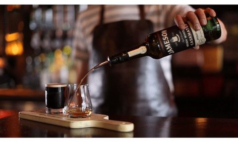 bartender pouring Jameson Caskmates Stout into a glass.