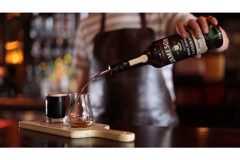 Bartender pouring Jameson Caskmates Stout into a glass.