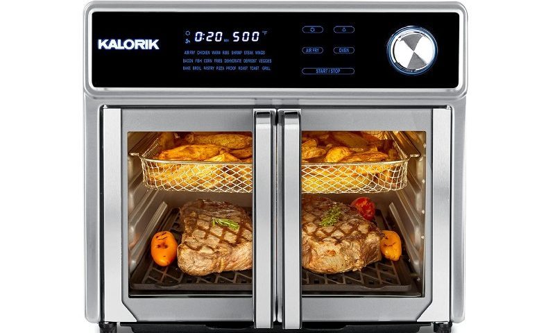 Steak and fries being cooked in a Kalorik Maxx Air Fryer.