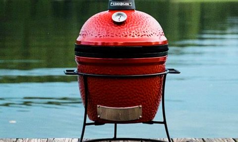 Kamado Joe Jr. 13.5 inch Charcoal Grill in Blaze Red on a dock.