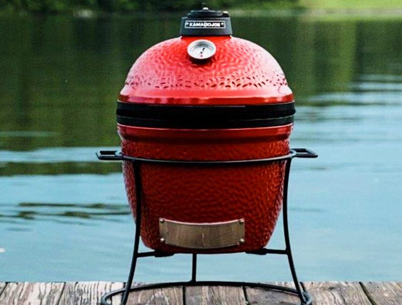 Kamado Joe Jr. 13.5 inch Charcoal Grill in Blaze Red on a dock.