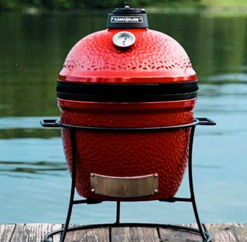 Kamado Joe Jr. 13.5 inch Charcoal Grill in Blaze Red on a dock.