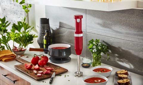Kitchenaid Cordless hand blender in red on a kitchen counter.