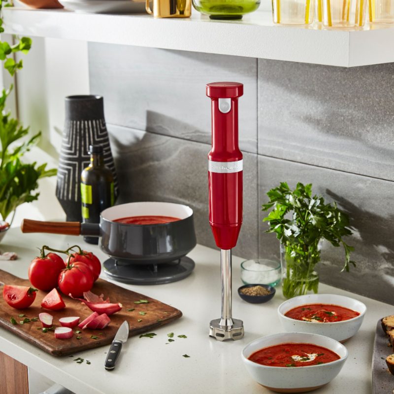 Kitchenaid Cordless hand blender in red on a kitchen counter.