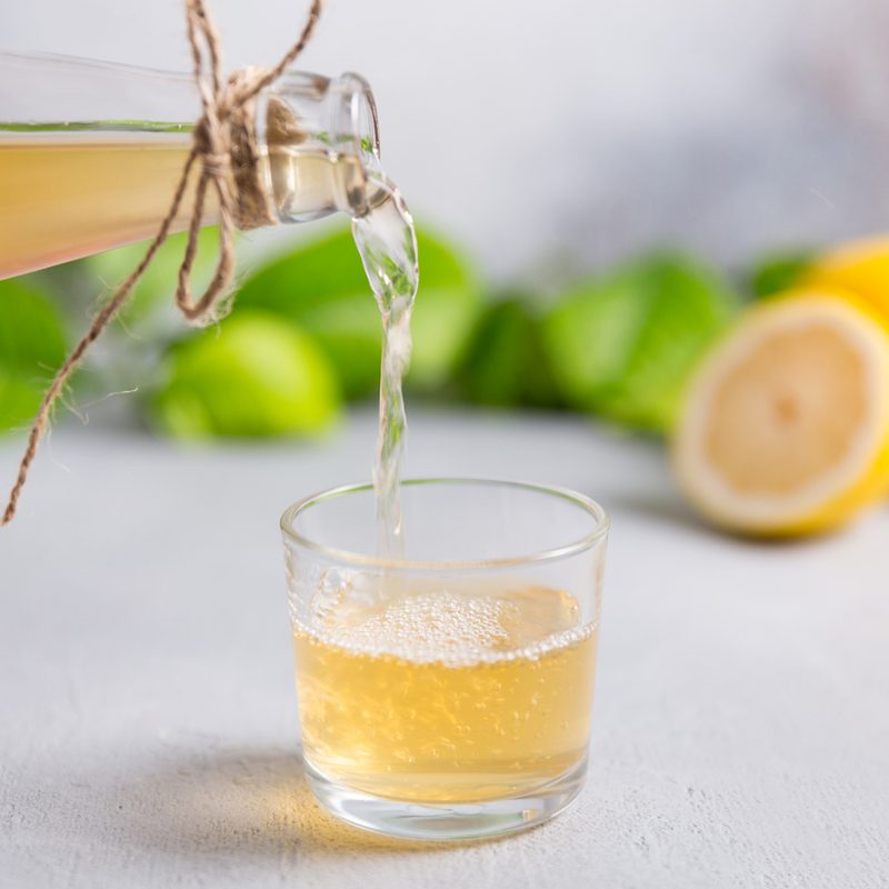 A bottle of kombucha being poured into a glass.