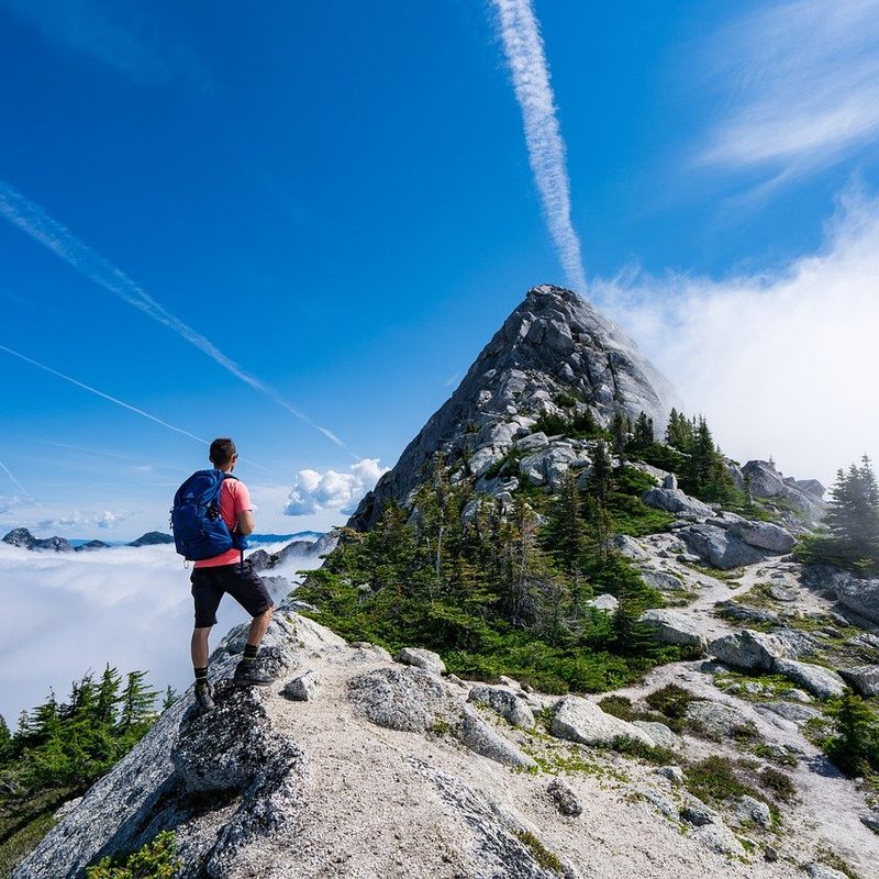 man hiking on rocky mountain peak