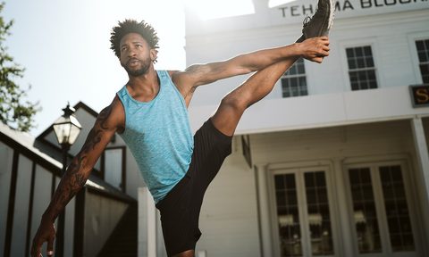 Man standing in an upright stretch.