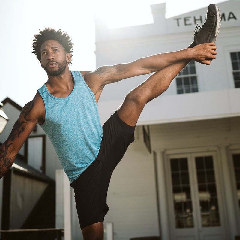 Man standing in an upright stretch.