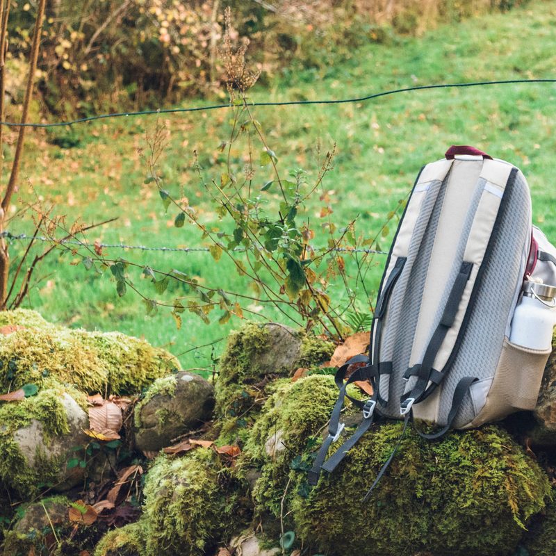 Outdoor Hiking backpack perched on rock with water bottle pocket.