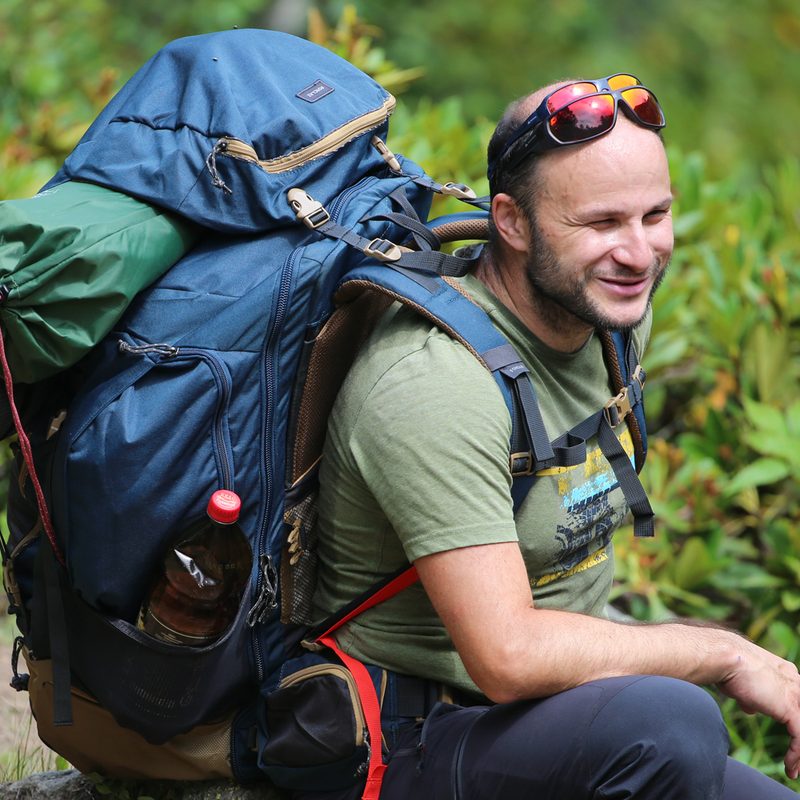 A hiker carrying his hiking pack and gear.