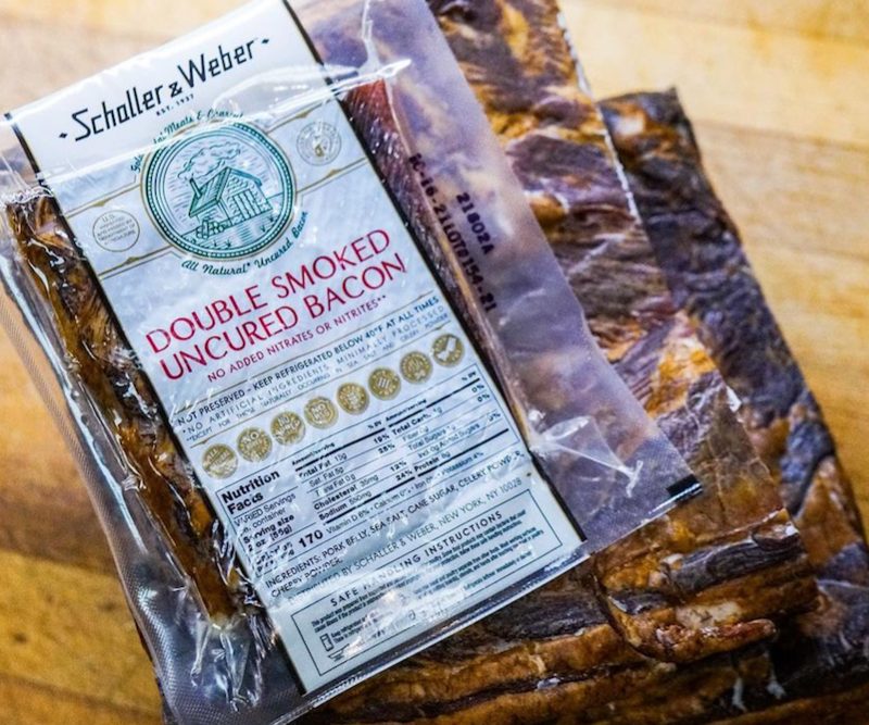 Schaller & Weber Uncured Double Smoked Bacone (whole) on wooden table.