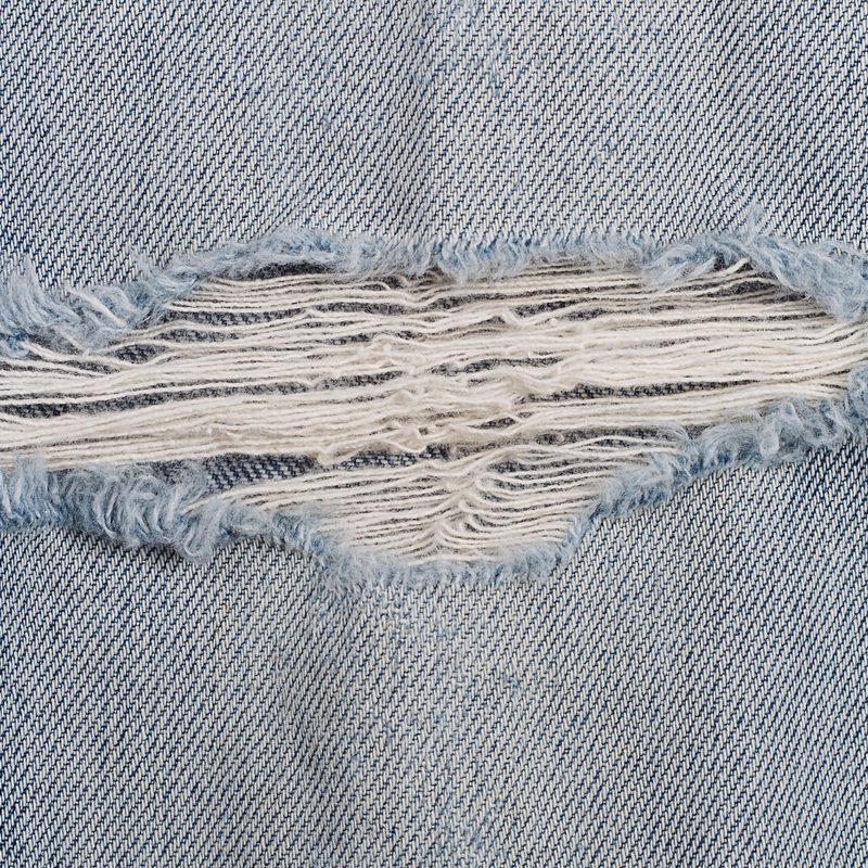 Close up view of a rip in ripped jeans.