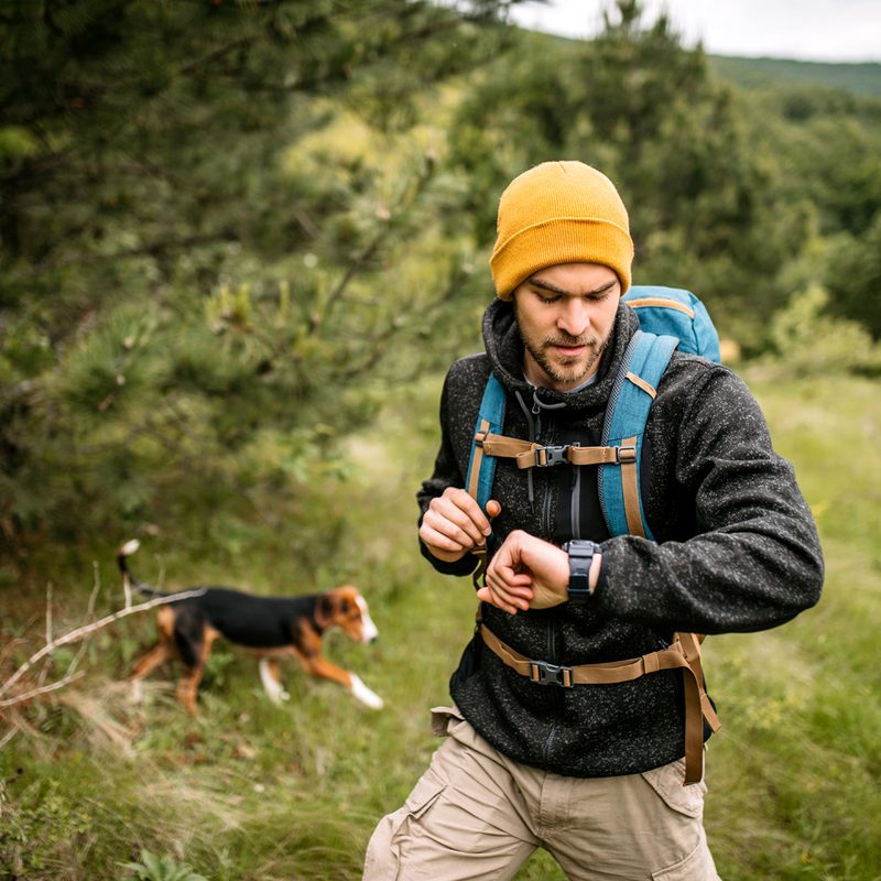 A male hiker checking the time on his watch