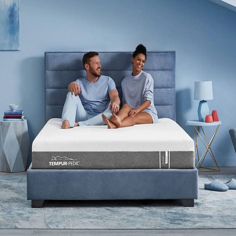 A couple on a Tempur-Cloud mattress in a blue bedroom.