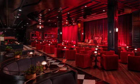 Dining tables and plush seats face The Twelve Thirty Supper Club's central stage.