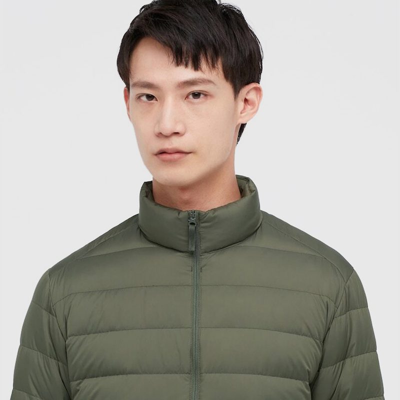 A portrait of a male model wearing a green Uniqlo Ultra Light Down Jacket.