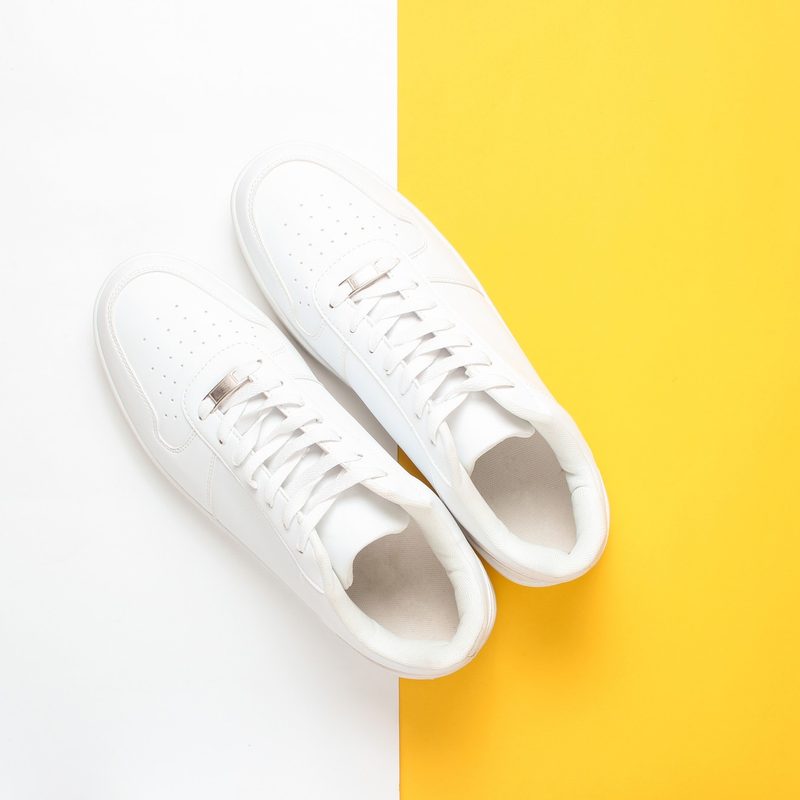 White sneakers on a white and yellow background.