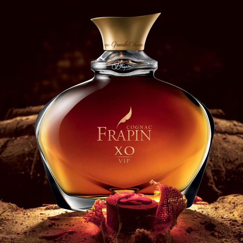 A bottle of Frapin VIP XO Cognac on top of a barrel.