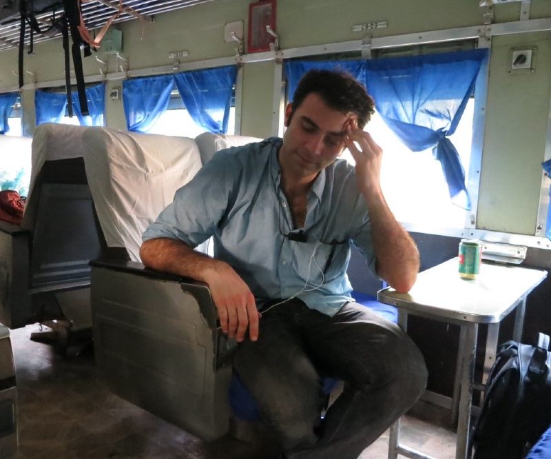 A tired Tom Vitale sitting on a bus.