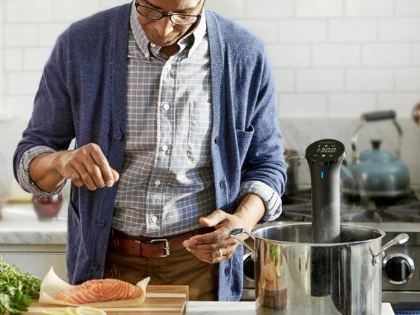 Anova Culinary Sous Vide Nano Precision Cooker in pot with man preparing more food.