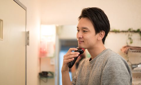 Man shaving with electric razor