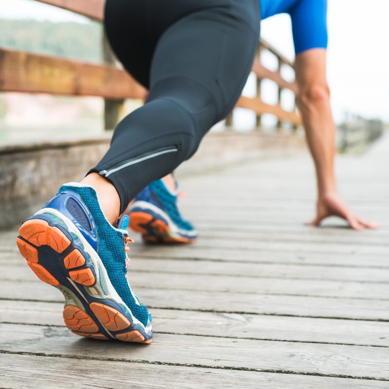 Fitness man ready for running on wooden walkway on park.