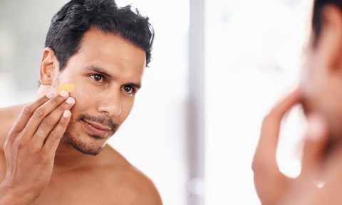 Man using tinted moisturizer on face.