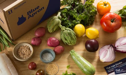 Blue Apron box next to food on table.