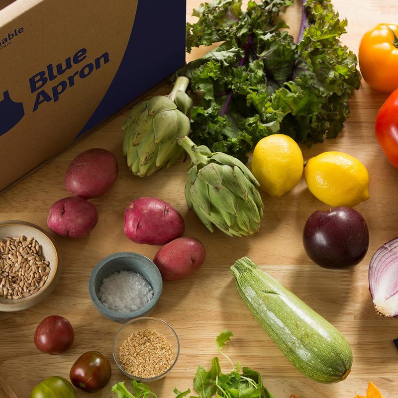 Blue Apron box next to food on table.