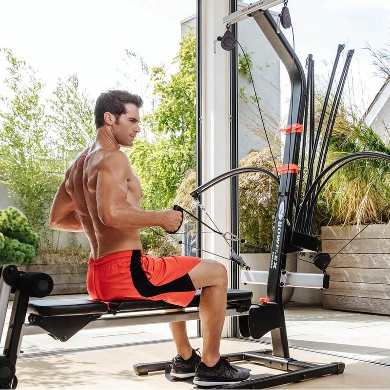 Man using the Bowflex Home Gym in an outdoor enclosed patio area.