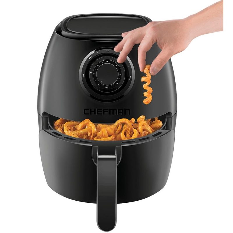 Chefman Turbofry Air Fryer full of curly fries with a hand picking one up, on a white background.