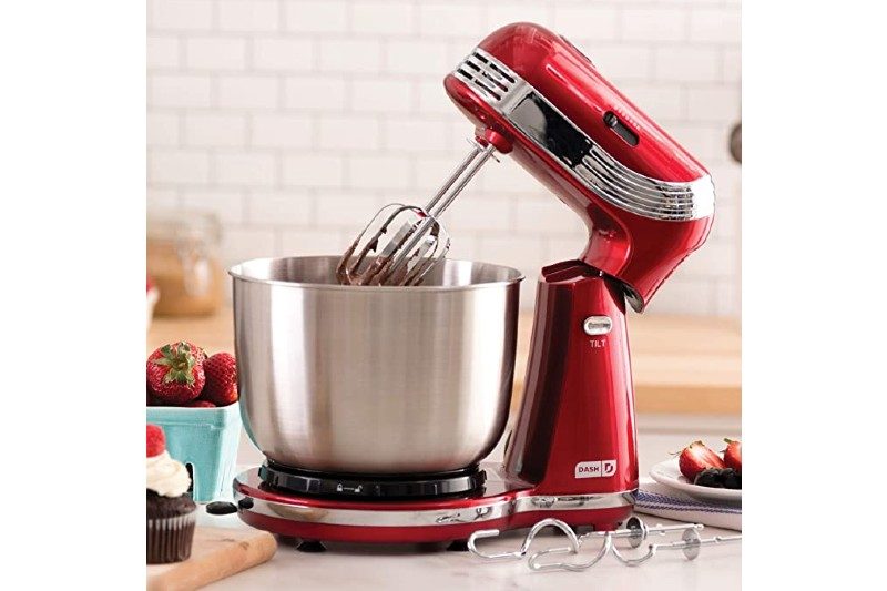 dash stand mixer sitting on a counter with food next to it.