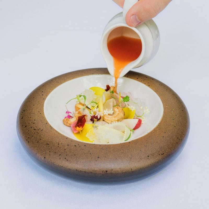 Sauce being poured into dish at Mozaic in Bali.