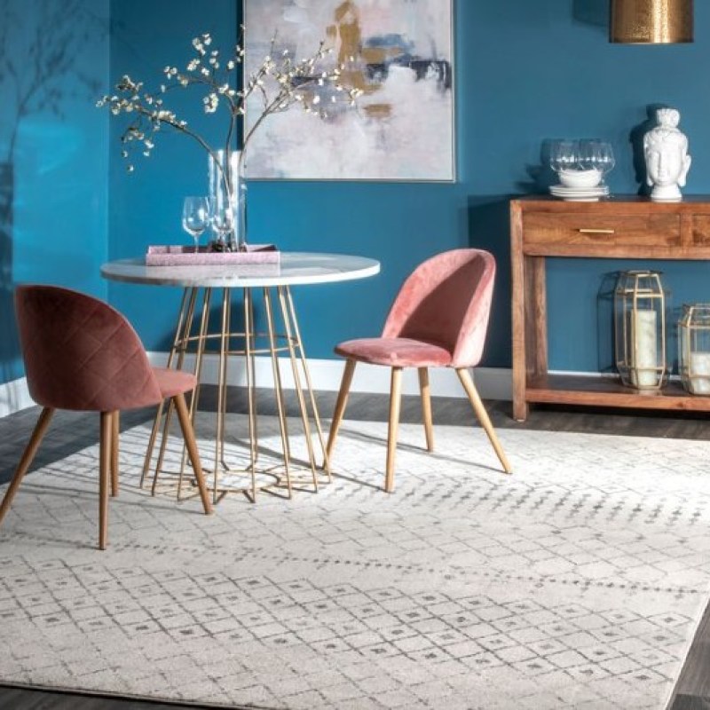 trellis rug sitting under a table and two chairs.