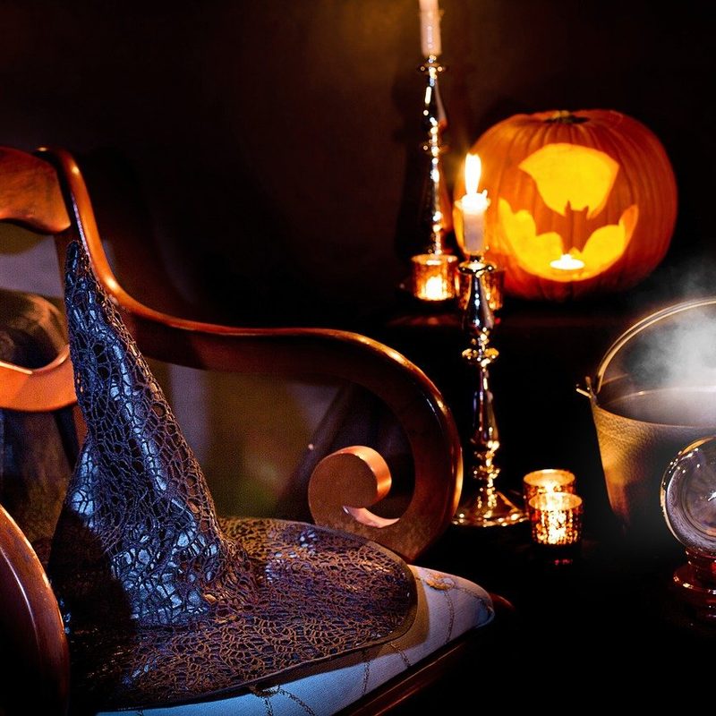 Halloween decor including a witch hat and candles.