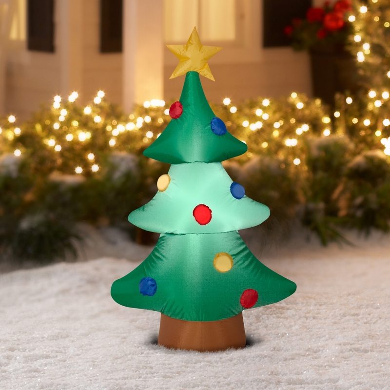 Inflatable Christmas Tree in snow-covered yard.