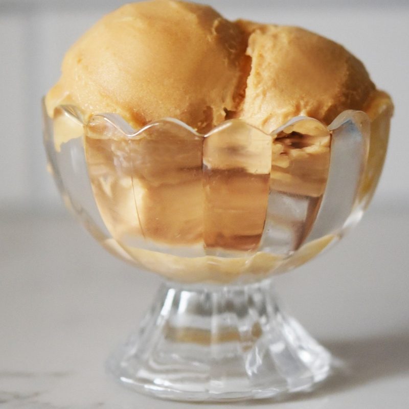 ninja creami lite apple pie ice cream scoops in a clear glass dish.
