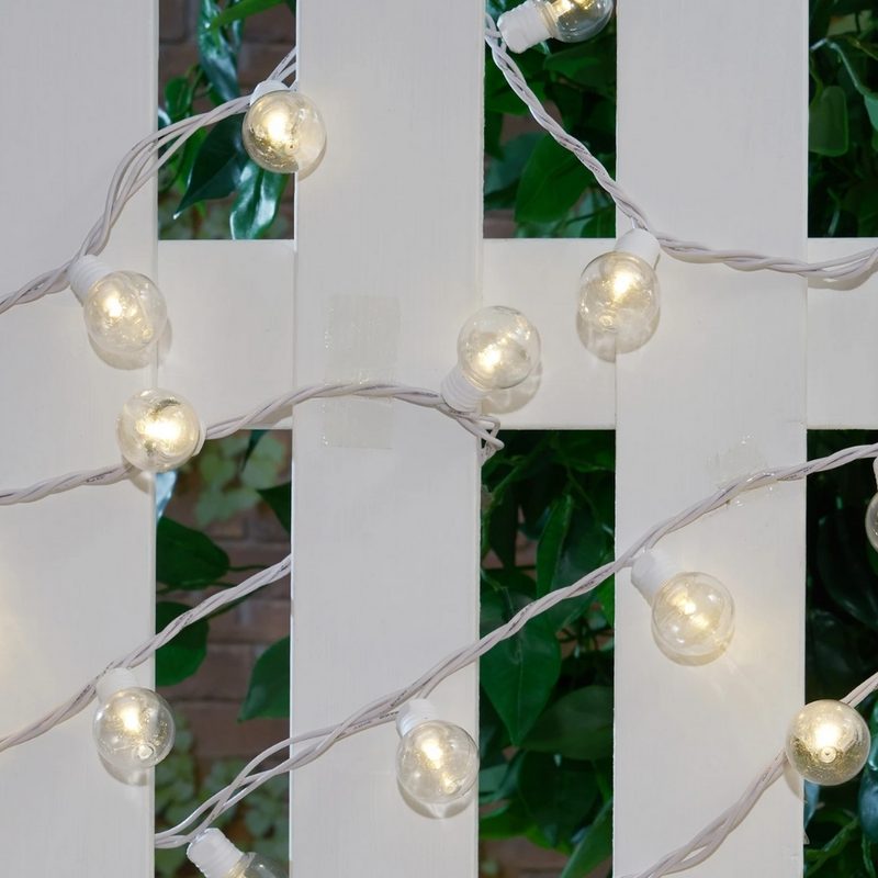 Mainstays String Lights on a white fence.