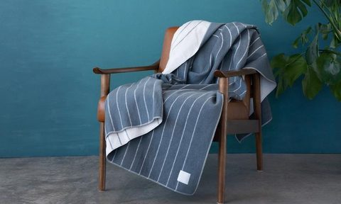 Rumpl's Merino SoftWool Blanket draped over a chair.
