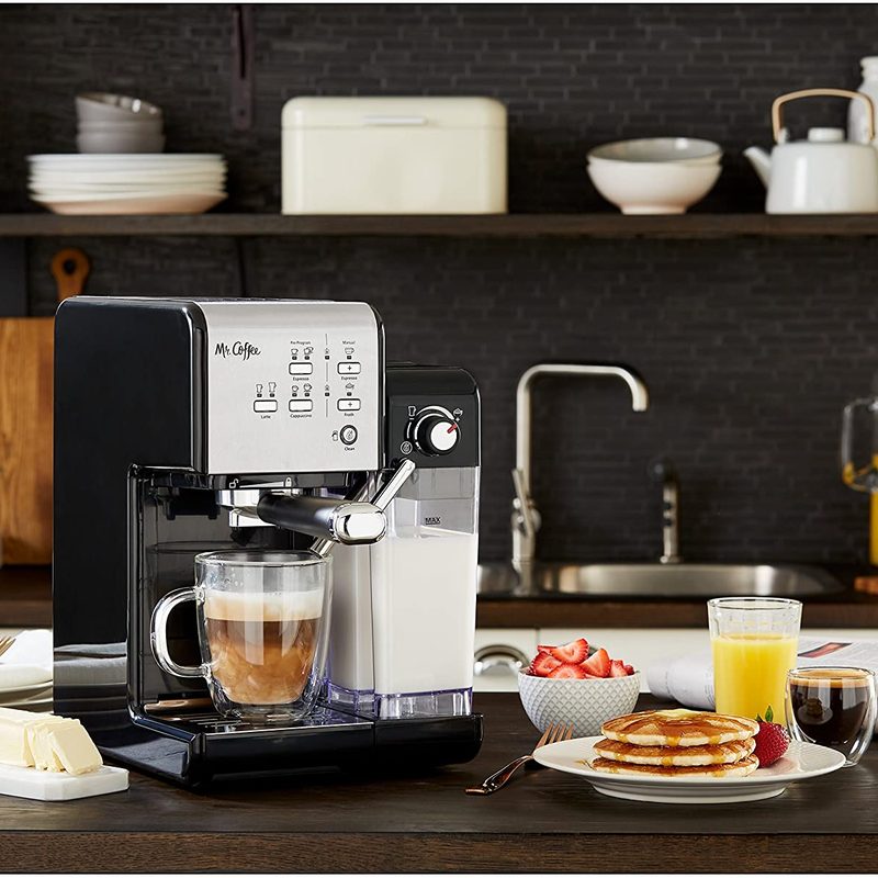 Mr Coffee one touch espresso maker in a kitchen setting with breakfast dishes.